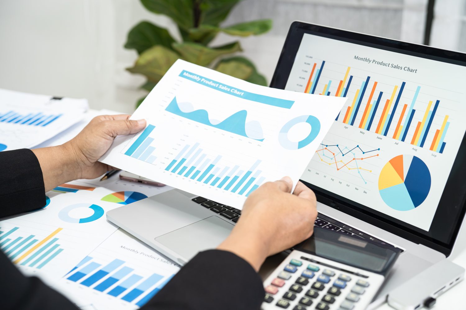 Analyst reviewing monthly product sales charts at an office desk